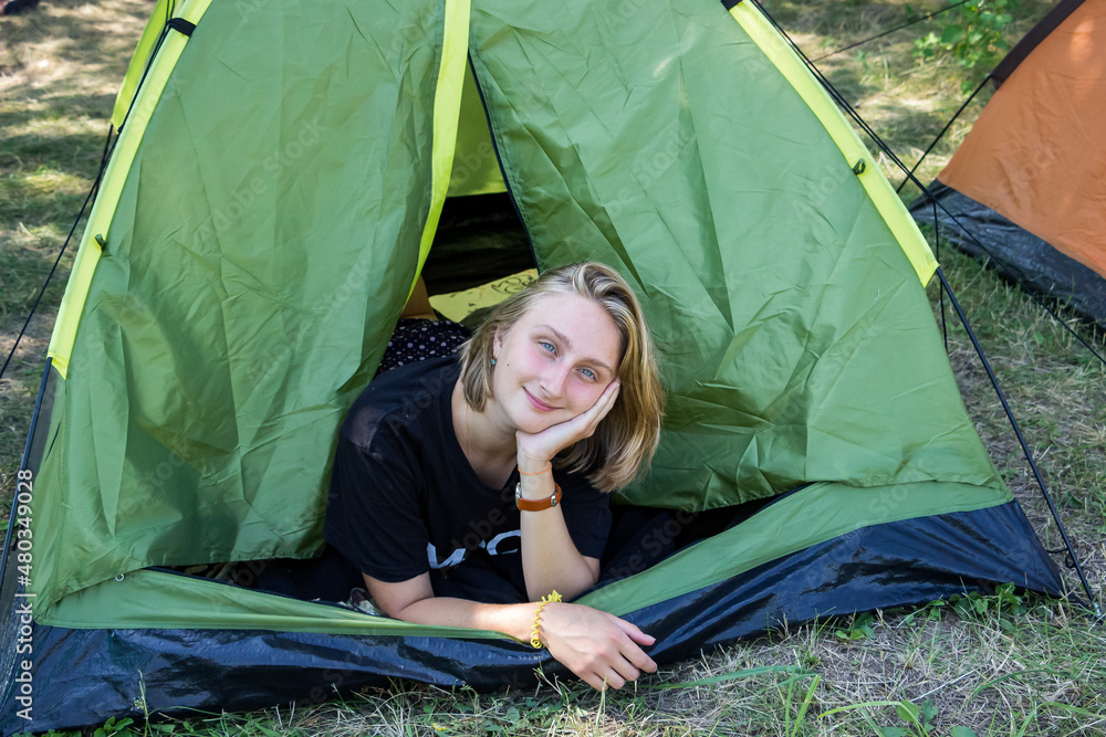 young girl schoolgirl in nature in a green tent - camping  
 