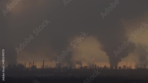 Factory chimneys pollute the air, environmental problems. It's snowing ash at sunset. Industrial pollution, exhaust fumes from the chimney. Industrial area, thick smoke. Climate change, ecology, atmos