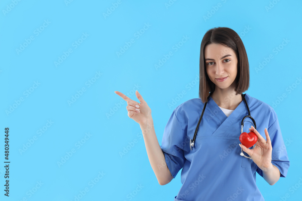Attractive female trainee nurse on blue background Attractive female trainee nurse on blue background