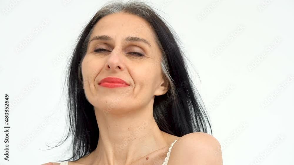 Female portrait of middle aged woman starting getting grey-haired in studio with naked shoulders on white background, face skin care beauty, middle age skincare cosmetics, cosmetology concept Female portrait of middle aged woman starting getting grey-haired in studio with naked shoulders on white background, face skin care beauty, middle age skincare cosmetics, cosmetology concept