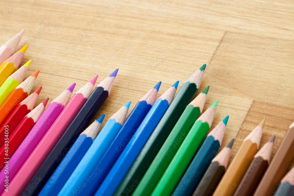 Line of Colorful Pencils on Wooden Table Line of Colorful Pencils on Wooden Table