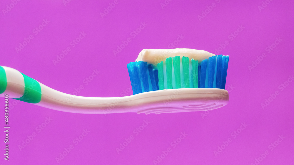 Toothbrush with toothpaste on a purple background, dental care Toothbrush with toothpaste on a purple background, dental care