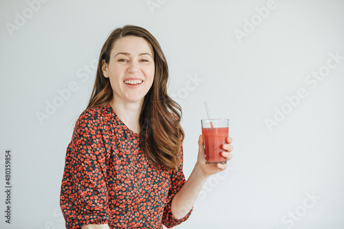 Woman holding a mug with red fruit smoothie. healthy lifestyle. Lose weight with a smoothie Copy space photo