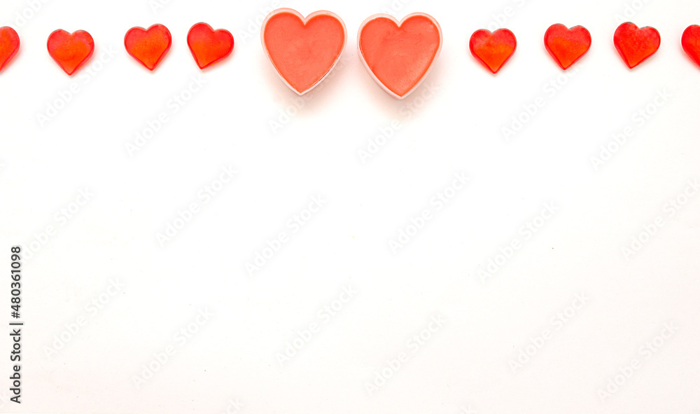 Two big romantic valentine hearts and several hearts on top on white background
