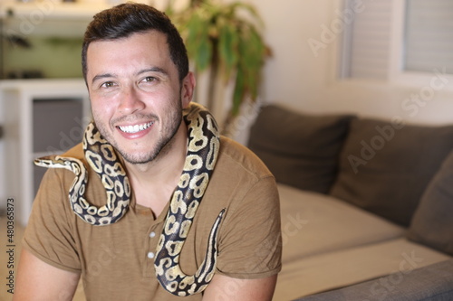 Cute man holding exotic ball python