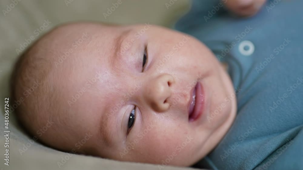 Lovely baby face with plump rosy cheeks. Cute baby boy lying his head turned right yawning sweetly in front of camera. Close up. Lovely baby face with plump rosy cheeks. Cute baby boy lying his head turned right yawning sweetly in front of camera. Close up.