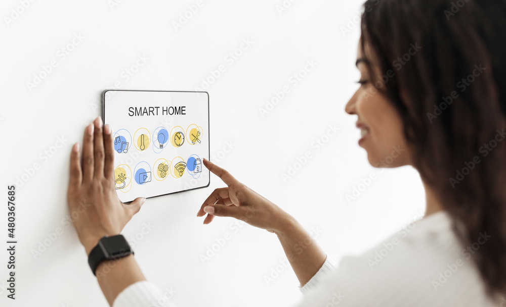 African american woman pressing on automatic panel on wall African american woman pressing on automatic panel on wall