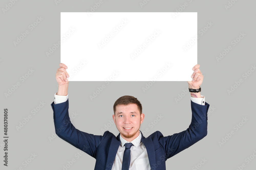A businessman in formal attire holds a rectangular white poster A businessman in formal attire holds a rectangular white poster