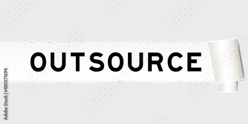 Ripped gray paper background that have word outsource under torn part