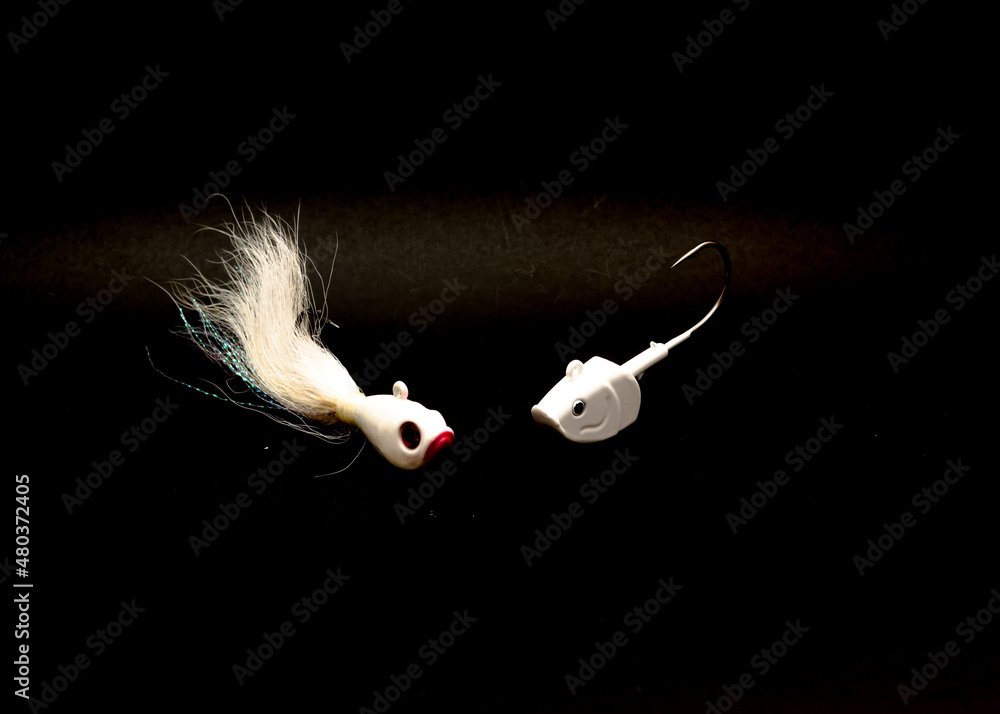 Close-up white Shad Jig Head and Hand tie deer hair fishing jig hooks  isolated on black Stock Photo
