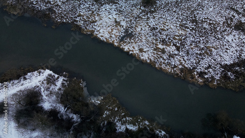 Flight over the snowy park. The river is visible. Aerial photography.