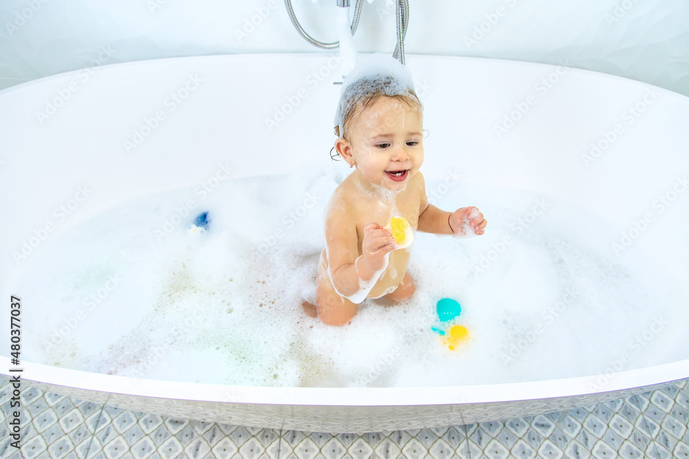 A child bathes in a bubble bath. Selective focus. A child bathes in a bubble bath. Selective focus.