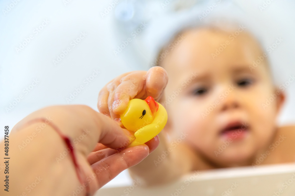 A child bathes in a bubble bath. Selective focus. A child bathes in a bubble bath. Selective focus.