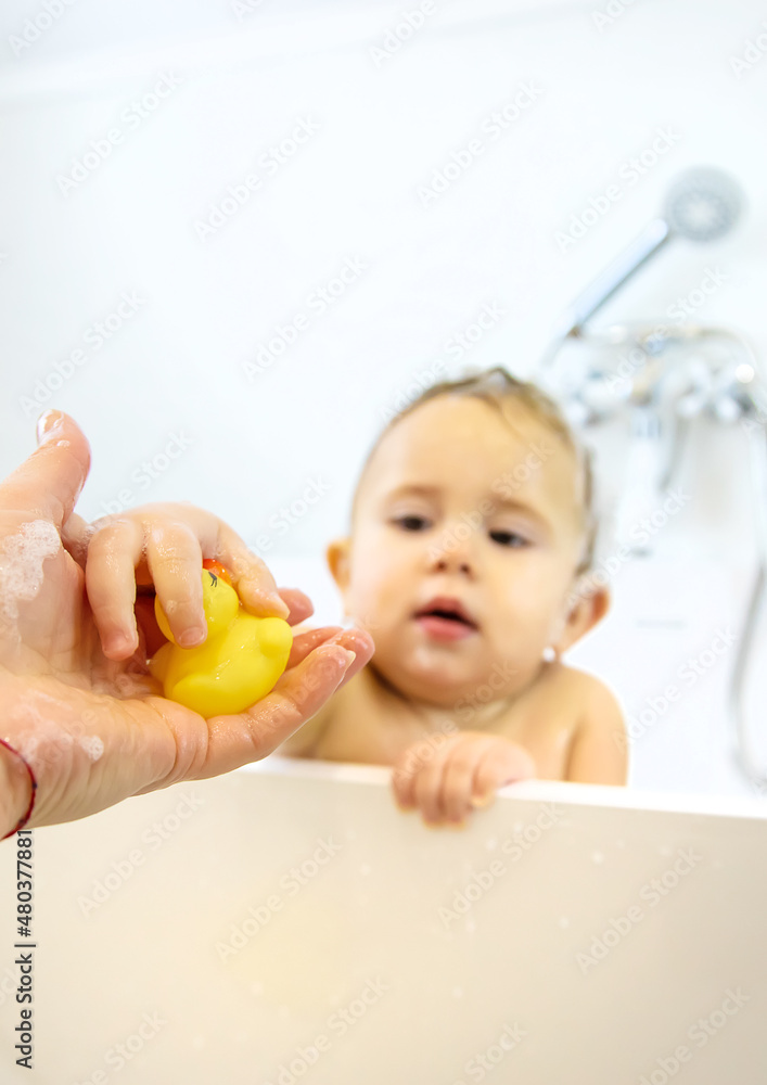 A child bathes in a bubble bath. Selective focus. A child bathes in a bubble bath. Selective focus.