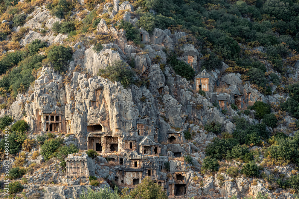 ruins of a rocky necropolis with tombs carved in stone in Myra Lycian