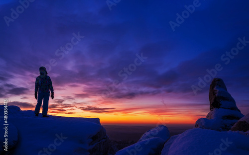 Silhouette of a man with hands raised in the beautiful sunset.