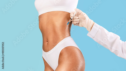 Woman having lipolysis treatment at beauty salon © Prostock-studio