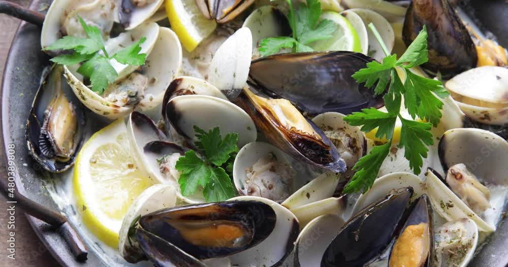 Mussels in a pan with parsley and lemon Mussels in a pan with parsley and lemon