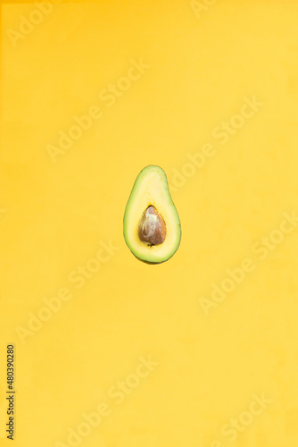 delicious green avocado from the orchard isolated on yellow background