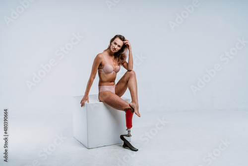 Amputated woman. Cinematic image of a beautiful young woman with leg prosthesis. photo