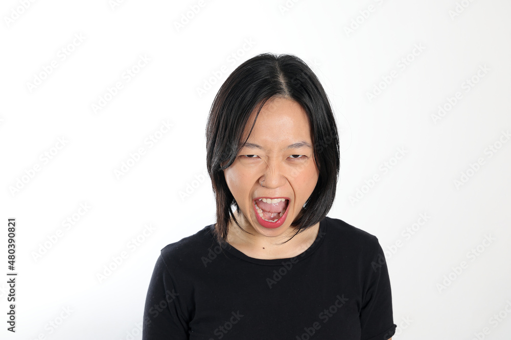 Young attractive south east asian woman pose face expression emotion on white background angry shout Young attractive south east asian woman pose face expression emotion on white background angry shout