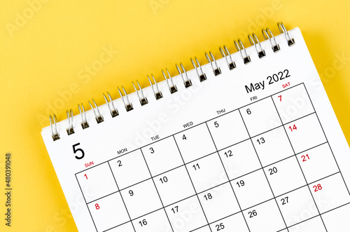 May 2022 desk calendar on yellow background.