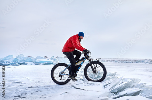 Man ride bicycle on the frozen lake.