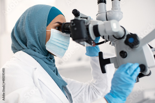 Muslim Medical Worker Lady Using Dental Microscope During Patient's Treatment