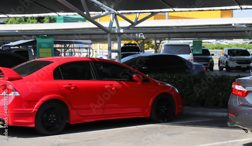 Closeup of rear side of red sedan car parking in parking area.