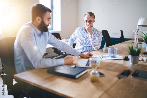 Professional caucasian 20s male colleagues having meeting to discuss planning and strategy for business partnership, skilled man employee talking with corporate owner share ideas for project