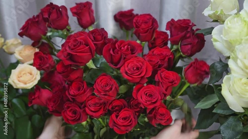 Florist arranging flowers in her shop. Young female flower shop owner working in flower shop