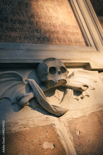 Skull with wings and an old text in the cemetary Fotobehang