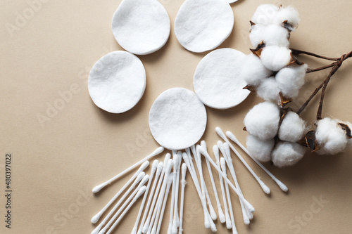 fluffy cotton flower cotton pads and cotton swabs on beige background with copy space. hygienic disposable product photo