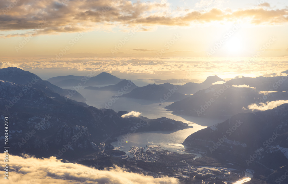 Aerial View of a small city, Squamish, in Howe Sound during winter season. Sunst Sky Art Render. Located north of Vancouver, British Columbia, Canada.