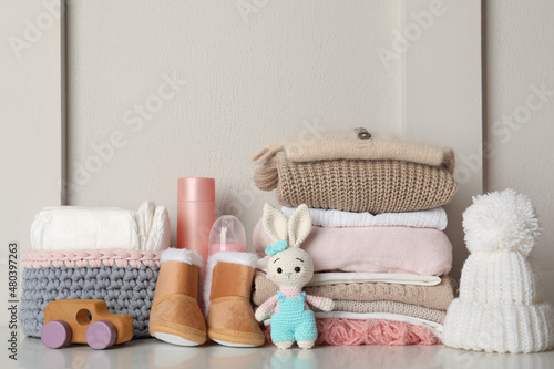 Baby clothes, toys and accessories on white table