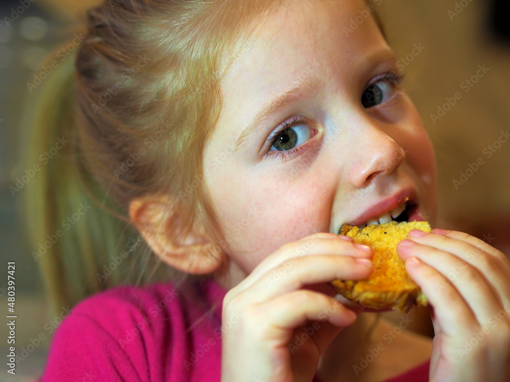 Cute blonde girl eats cookies. Sweets for children. Cute blonde girl eats cookies. Sweets for children.