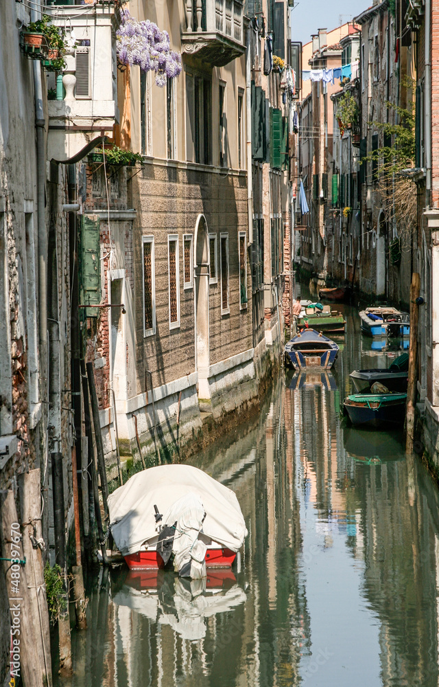 narrow canal in venice with parking boats