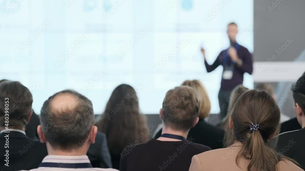 People watching business presentation in auditorium People watching business presentation in auditorium