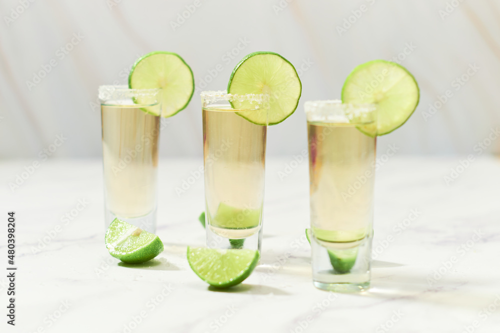 Three traditional tequila shots with lime and salt. Mexican tradition. Three traditional tequila shots with lime and salt. Mexican tradition.