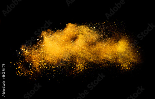 Yellow flour explosion on black background.