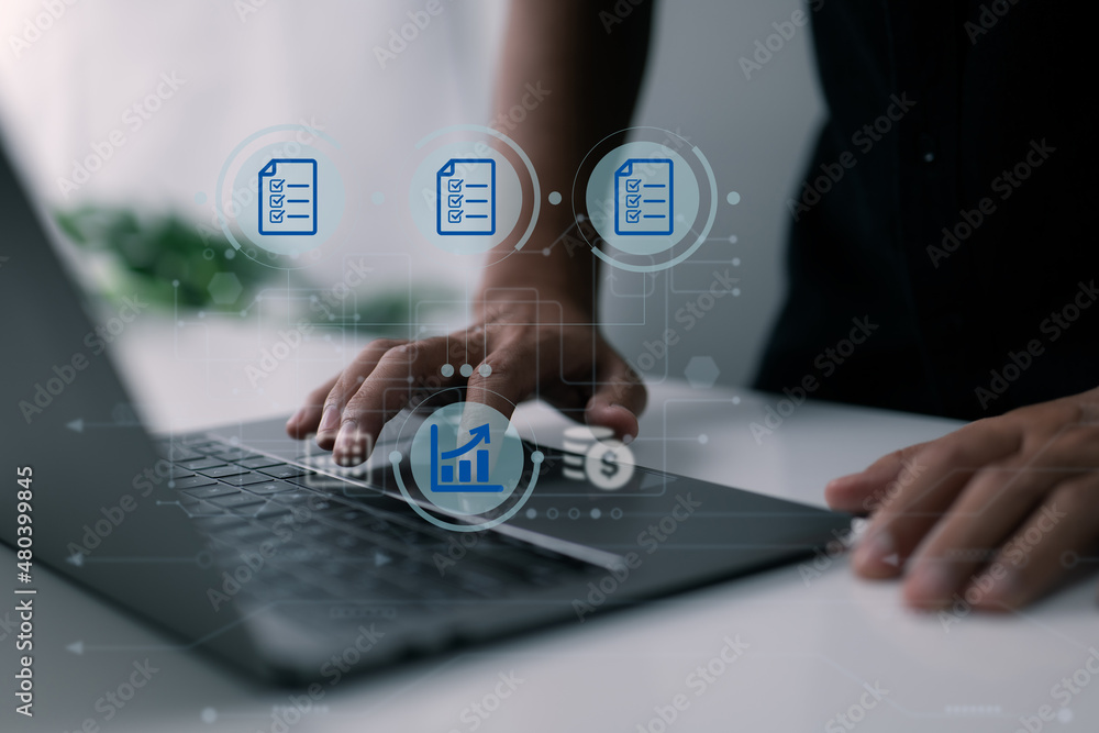 A man uses a computer to manage his family's company, keep track of records, paperwork, and keep track of revenue and costs. A man uses a computer to manage his family's company, keep track of records, paperwork, and keep track of revenue and costs.
