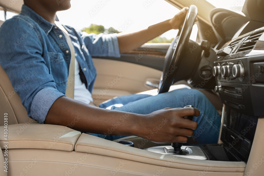 Unrecognizable african american guy holding hand on gear, driving car Unrecognizable african american guy holding hand on gear, driving car