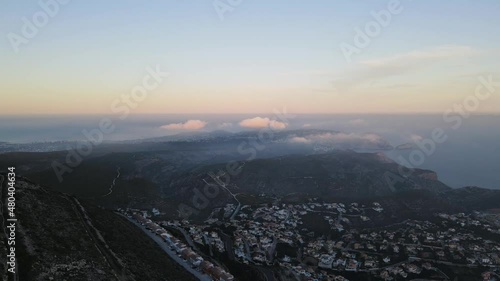 Fooggy sunset in Cumbre del sol. The fog hides the horizon and de coastline. Drone views from Benitachell, Moraira, Calpe and Jávea, in Alicante, Spain photo