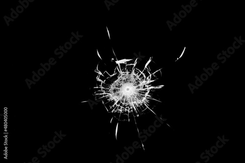 Fotografie, Obraz Texture of broken glass. Hole from a ball on a black background.