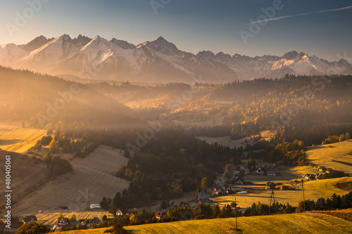 Autumn views of the Tatra Mountains from the surrounding hills. You can see the contrast between the snow above and the yellow leaves below.