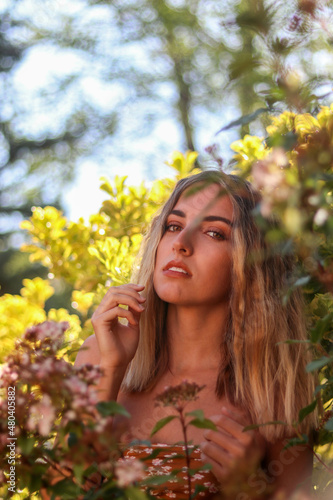 Portrait of young  beautiful blonde woman with wavy hair posing in nature
