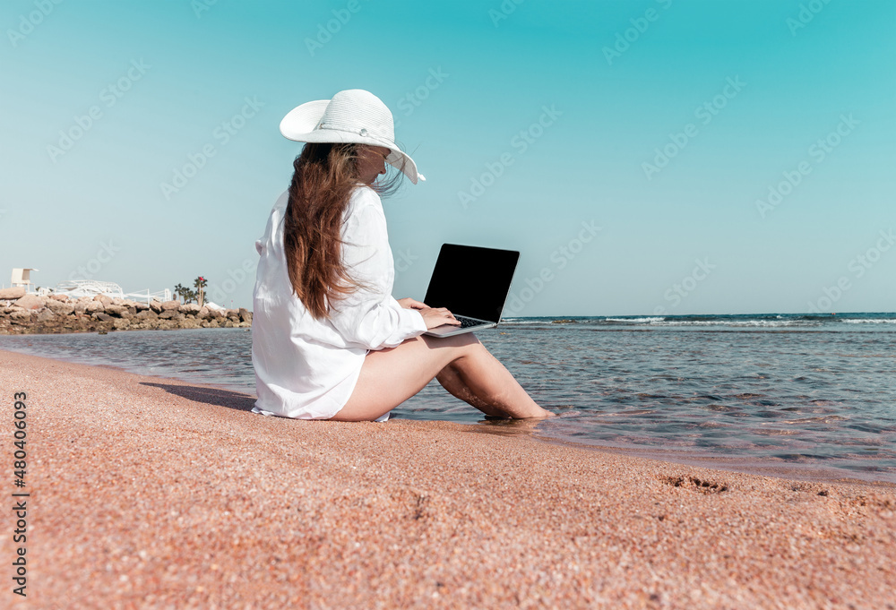 freelancer with a laptop works on a beach