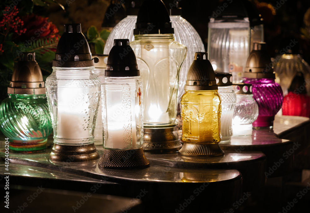 Foto de Cemetery grave candle lanterns, illuminated by night. All