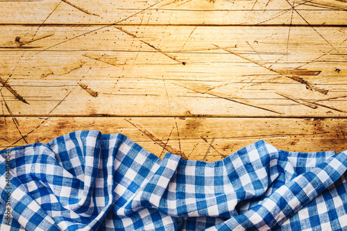 Billede på lærred Blue white checkered kitchen towel on old wooden background