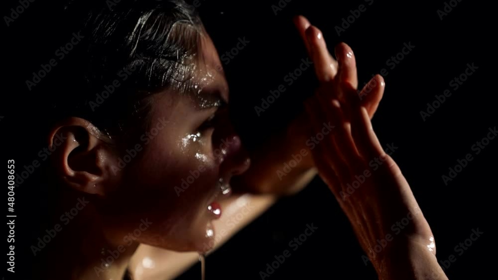 emotional woman in shower or rain, playing with light sensually, water is flowing over face emotional woman in shower or rain, playing with light sensually, water is flowing over face